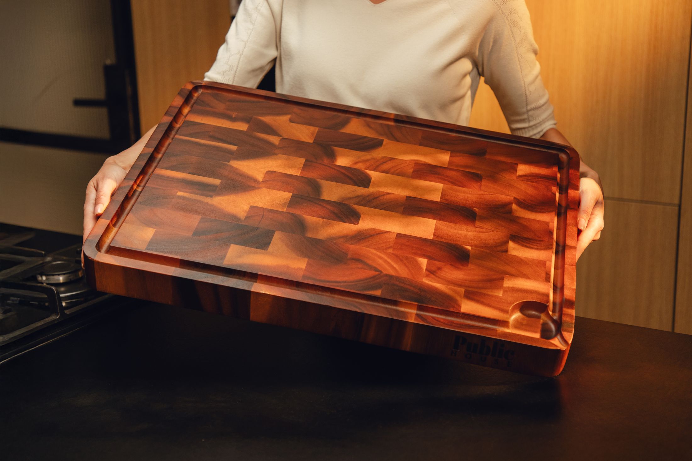 A Public House end-grain acacia board held over a kitchen bench