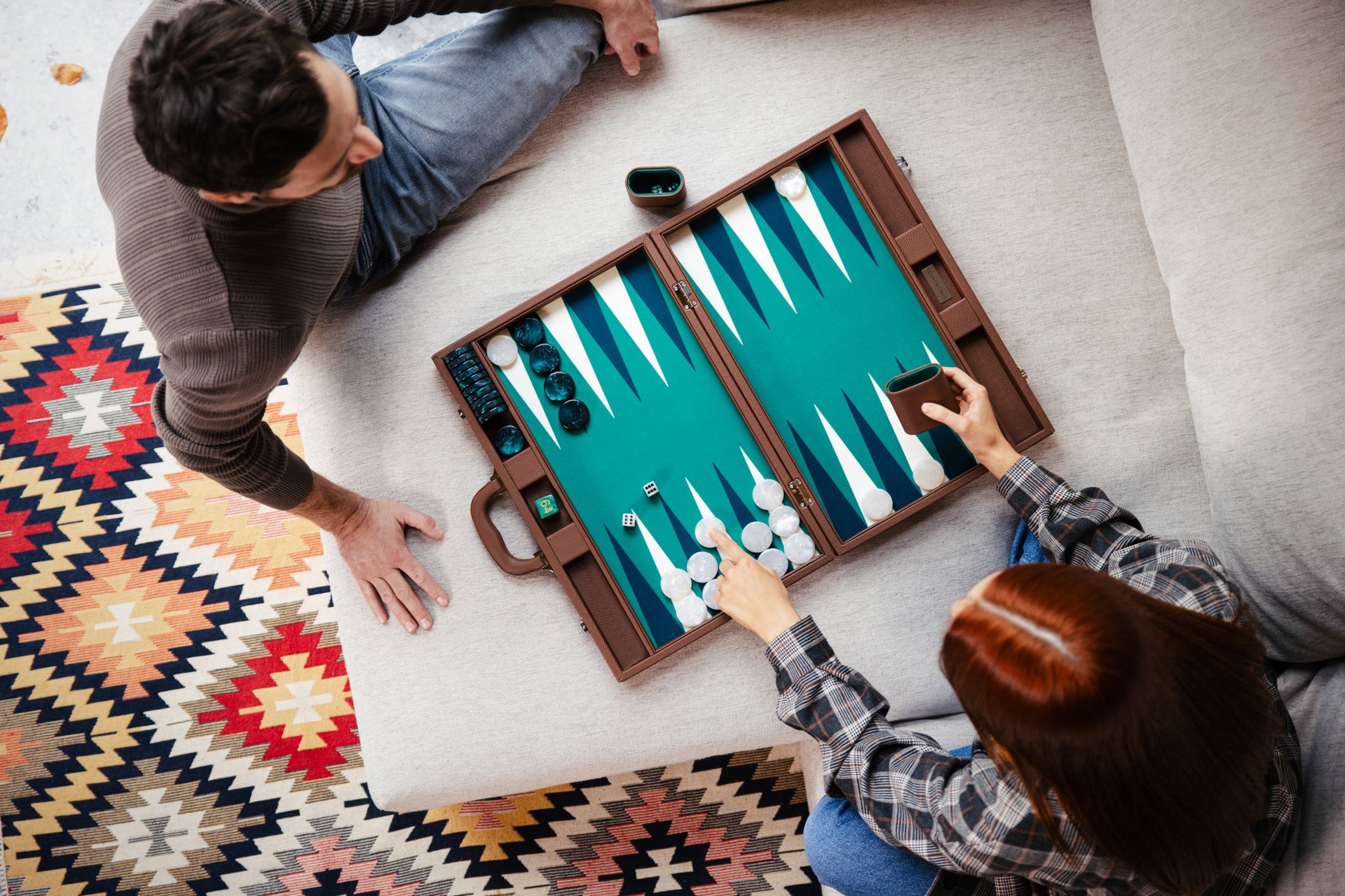 Overhead view of a couple playing backgammon on a sofa